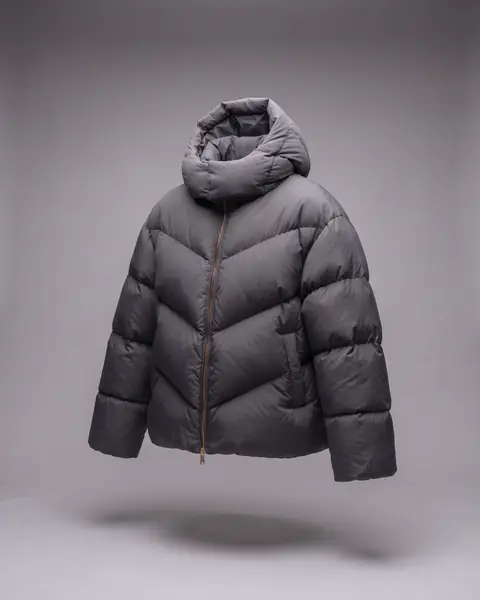 The same jacket from a three-quarter view, zipped, with the hood folded down into the collar.
