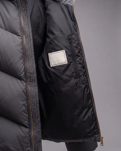 The inside of the open jacket: black lining, a zipped inner pocket and one blank off-white woven label.