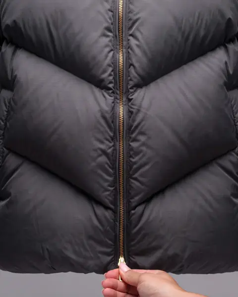 The film: a hand zips the jacket: Halfway